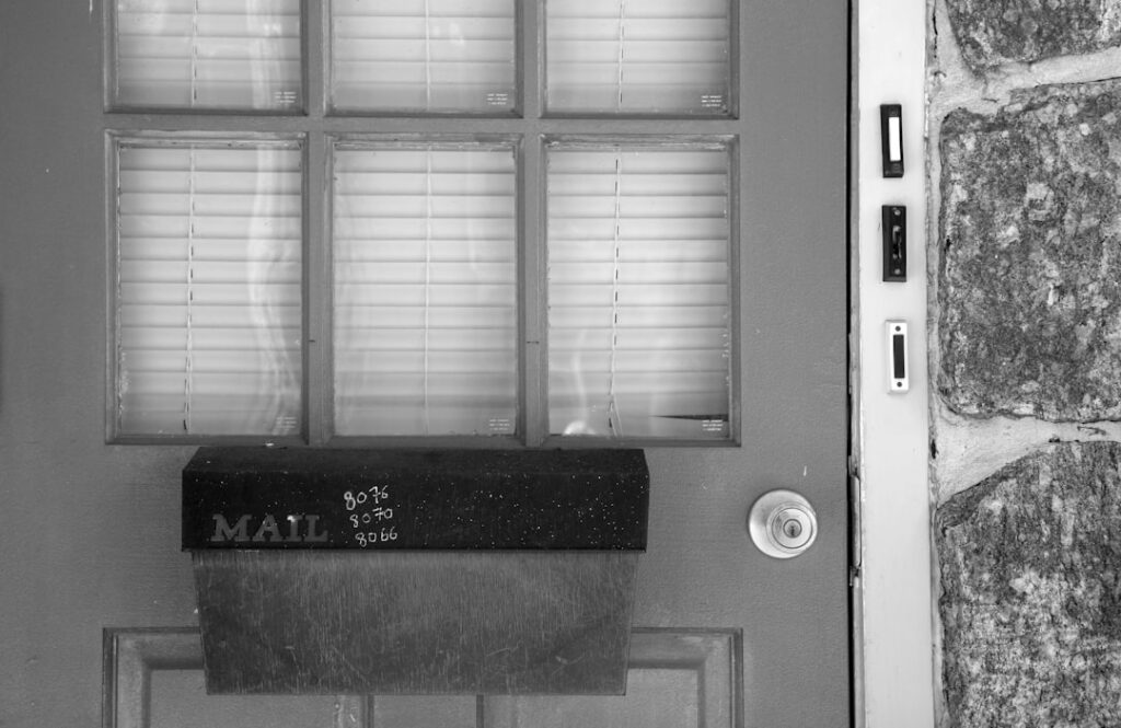 Mailbox attached to a door with glass panes.